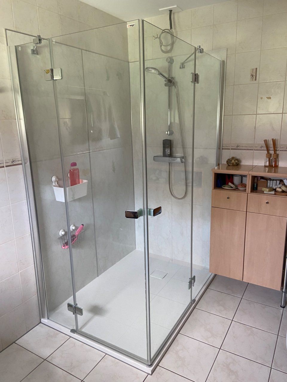 Fugenlose Glasdusche in einem frisch sanierten Badezimmer, umgesetzt von HSA Scharrenbroich aus Stockerau. Die moderne Dusche mit bodengleichem Einstieg und Glaswänden betont die barrierefreie, pflegeleichte Gestaltung.