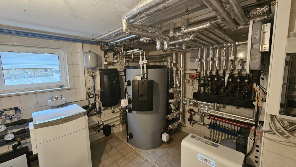 Ein Raum mit einem großen Wasserheizer und weiterer Heizungs- und Sanitärtechnik.